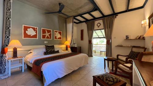 a bedroom with a bed and a chair in a room at Pinewood Beach Resort and Spa in Diani Beach