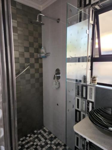a shower with a glass door in a bathroom at Umhlanga Rocks Guesthouse flat in Durban