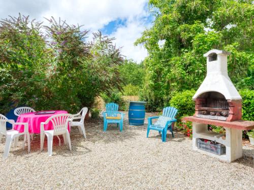 a patio with a table and chairs and a fireplace at Holiday Home Pontac-Gadet 2 - JDL101 by Interhome in Jau-Dignac-et-Loirac