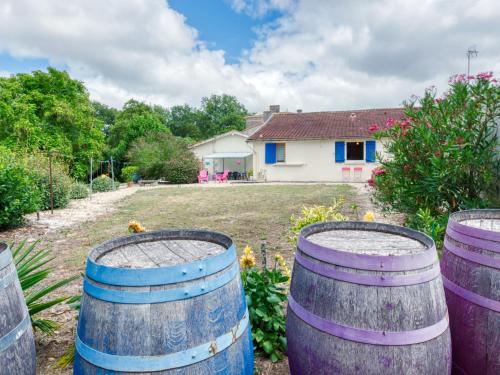 a group of wine barrels in front of a house at Holiday Home Pontac-Gadet 2 - JDL101 by Interhome in Jau-Dignac-et-Loirac