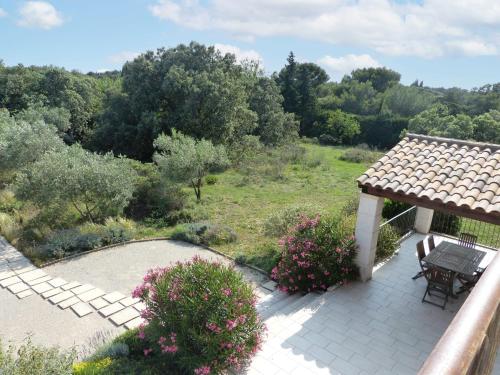 un patio con mesa y sillas y un jardín en Holiday Home La Garrigue - PUJ100 by Interhome, en Pujaut