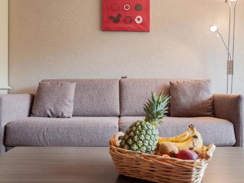 a basket of fruit on a table in front of a couch at Apartment Rosablanche C51 by Interhome in Siviez