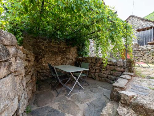 a table and chairs sitting in a stone wall at Holiday Home Chassezac by Interhome in Sainte-Marguerite-Lafigère