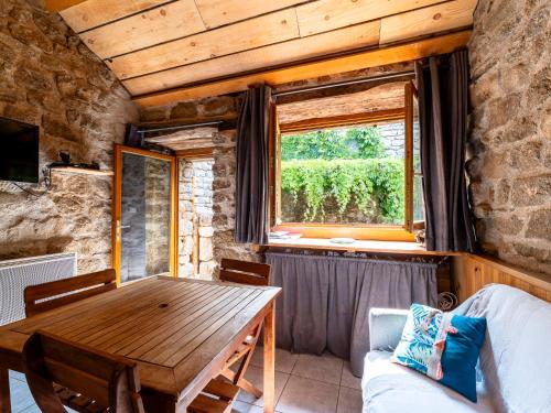 une salle à manger avec une table en bois et une fenêtre dans l'établissement Holiday Home Chassezac by Interhome, à Sainte-Marguerite-Lafigère