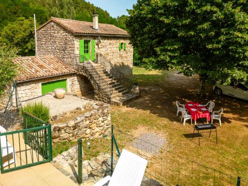 an old stone house with a table and chairs at Holiday Home Le Moulin - SGB100 by Interhome in Saint-Genest-de-Bauzon