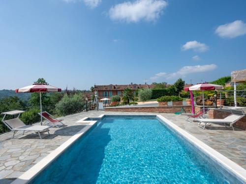 a swimming pool with chairs and umbrellas on a house at Holiday Home Bricco delle Rondini by Interhome in Villata