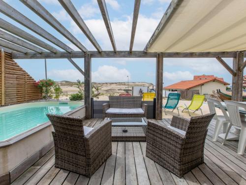 a patio with chairs and a swimming pool at Holiday Home Les Baïnes - VIB220 by Interhome in Vieux-Boucau-les-Bains