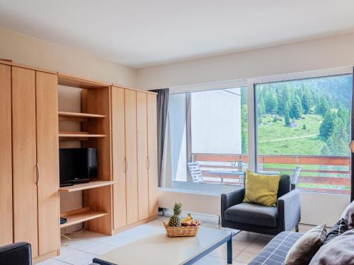 - un salon avec un canapé, une chaise et une fenêtre dans l'établissement Apartment Rosablanche C64 by Interhome, à Siviez