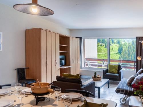 a living room with a couch and a table and chairs at Apartment Rosablanche C64 by Interhome in Siviez