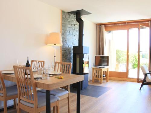 ein Esszimmer mit einem Tisch und einem Kamin in der Unterkunft Apartment Meribel 1 by Interhome in Villars-sur-Ollon