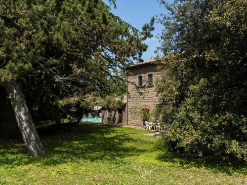 een stenen gebouw in een tuin met een boom bij Apartment La Capraccia - BOL334 by Interhome in Bagnoregio