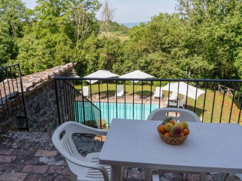 a table with a bowl of fruit on a balcony at Apartment La Capraccia-7 by Interhome in Bagnoregio