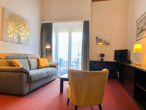 ein Wohnzimmer mit einem Sofa und einem Stuhl in der Unterkunft Apartment Parcolago - Utoring-57 by Interhome in Caslano