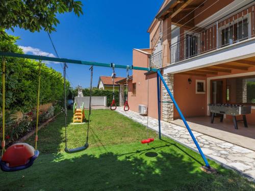 a yard with a swing set in a house at Holiday Home Villa Anamaria by Interhome in Plovanija