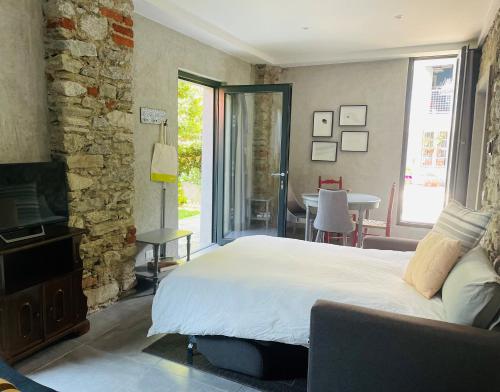 una camera con letto, TV e tavolo di Villa Bacchetta - Stone Cottage a Oleggio Castello