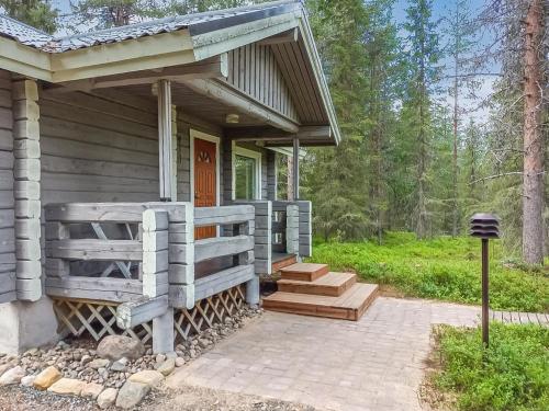 ein Holzhaus mit einer Veranda und einer Treppe in der Unterkunft Holiday Home Pelkkaveska by Interhome in Ruka