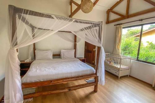 a bedroom with a canopy bed and a crib at A two bedroom Cabin along Njoro Rd, Nakuru County. in Nakuru