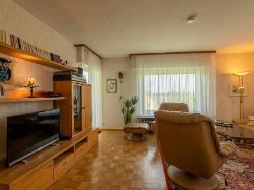 ein Wohnzimmer mit einem TV und einem Stuhl in der Unterkunft Holiday Home Uhu by Interhome in Dittishausen