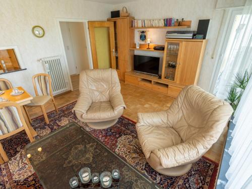 ein Wohnzimmer mit 2 Stühlen und einem TV in der Unterkunft Holiday Home Uhu by Interhome in Dittishausen