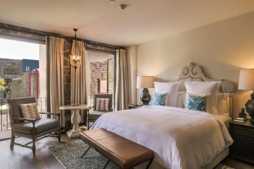 a bedroom with a large bed and a balcony at Banyan Tree Puebla in Puebla