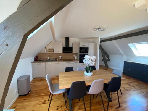 een keuken en eetkamer met een houten tafel en stoelen bij Appartement T3 en plein cœur du centre-ville in Soissons
