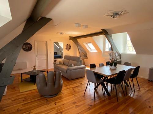 a living room with a table and a couch at Appartement T3 en plein cœur du centre-ville in Soissons