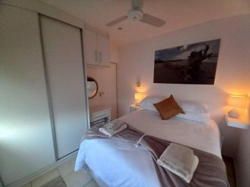ein Schlafzimmer mit einem großen weißen Bett mit zwei Kissen in der Unterkunft Ocean Breeze @ 8 Ogwini in Uvongo Beach