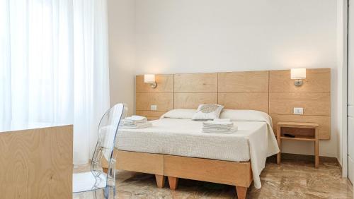 ein Schlafzimmer mit einem Bett und einem Stuhl in der Unterkunft Ammarèa B&B in Torre San Giovanni Ugento
