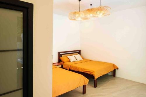 - 2 lits dans une chambre avec des draps orange dans l'établissement Casas Del Sol - Luxe 3 Bedroom Tropical Villa & Private Pool, à San Felipe