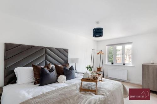 sypialnia z dużym łóżkiem z drewnianym zagłówkiem w obiekcie Guildford - 3 Bedroom Home - Driveway & Garden w mieście Guildford