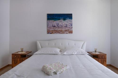 een slaapkamer met een wit bed en 2 nachtkastjes bij Apartment Da Lia in Momjan