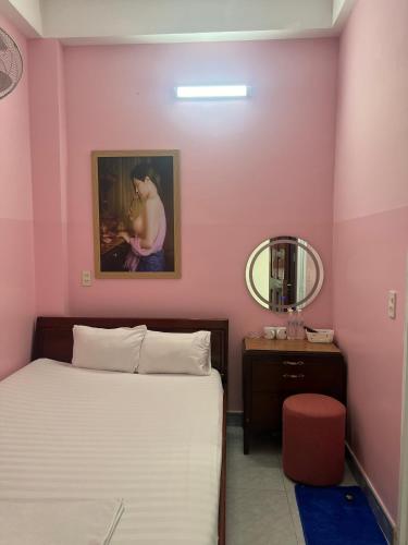 a pink bedroom with a bed and a mirror at Nhà nghỉ 2552, đường D4 , KDC Võ Thị Sáu , phường Thống Nhất , thành phố Biên Hòa in Bien Hoa