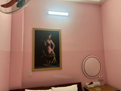 a painting of a pregnant woman on a pink wall at Nhà nghỉ 2552, đường D4 , KDC Võ Thị Sáu , phường Thống Nhất , thành phố Biên Hòa in Bien Hoa