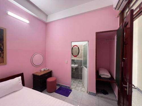 a pink bedroom with a bed and a mirror at Nhà nghỉ 2552, đường D4 , KDC Võ Thị Sáu , phường Thống Nhất , thành phố Biên Hòa in Bien Hoa