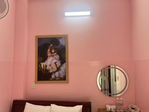 a painting of a woman sitting on a couch next to a mirror at Nhà nghỉ 2552, đường D4 , KDC Võ Thị Sáu , phường Thống Nhất , thành phố Biên Hòa in Bien Hoa