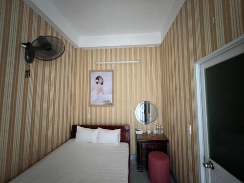 a bedroom with a bed and a table and a mirror at Nhà nghỉ 2552, đường D4 , KDC Võ Thị Sáu , phường Thống Nhất , thành phố Biên Hòa in Bien Hoa