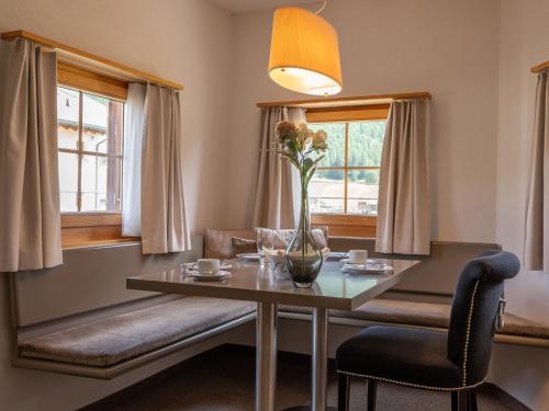 ein Esszimmer mit einem Tisch und 2 Fenstern in der Unterkunft Apartment Allegra Sur Inn by Interhome in Zuoz