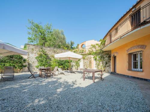 a patio with tables and an umbrella next to a building at Apartment Casa del Gemmo by Interhome in Sestri Levante