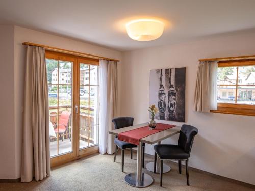 ein Esszimmer mit einem Tisch, Stühlen und einem Fenster in der Unterkunft Apartment Allegra Sur Castlatsch by Interhome in Zuoz