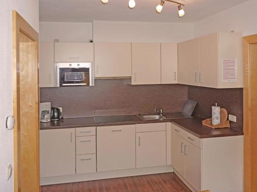 a kitchen with white cabinets and a sink at Apartment Flirscherblick by Interhome in Flirsch