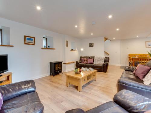 a living room with two couches and a tv at Holiday Home Carnevas by Interhome in Saint Merryn