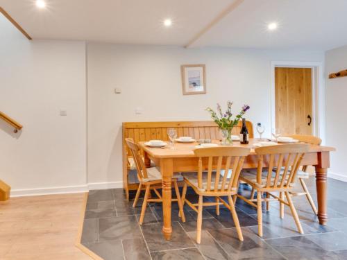 a dining room with a wooden table and chairs at Holiday Home Carnevas by Interhome in Saint Merryn