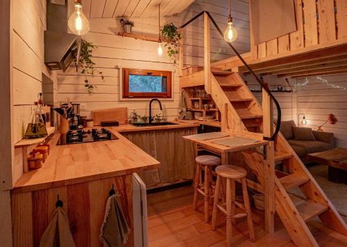 uma cozinha com uma escada numa pequena casa em L'Abri des Rêves em Aydat