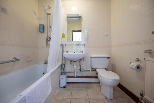 a bathroom with a toilet and a sink at Wellow Hotel in Cleethorpes