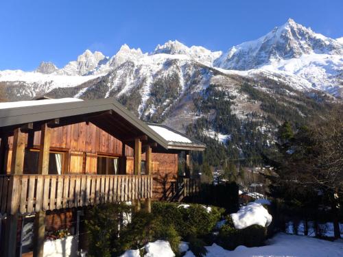 a house with snow covered mountains in the background at Apartment Clos des Outannes by Interhome in Chamonix