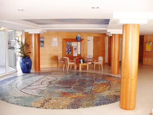 um átrio com piso em mosaico, uma mesa e cadeiras em Appartement Douarnenez Résidence en bord de plage em Douarnenez