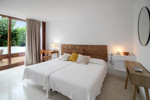 a white bedroom with a large bed and a desk at Two Bedroom Golf Bungalow On La Manga Club in Atamaría