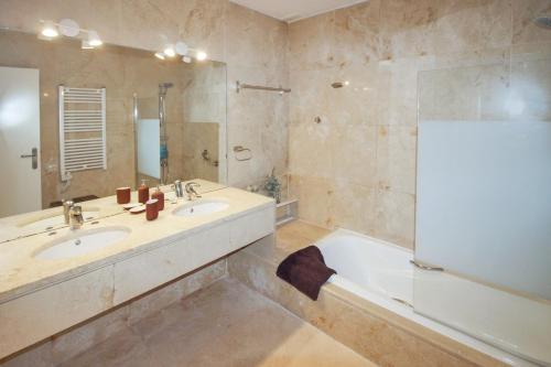 Atamaría的住宿－Two Bedroom Golf Bungalow On La Manga Club，带浴缸、两个盥洗盆和浴缸的浴室。