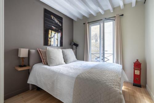 une chambre avec un lit blanc et une fenêtre dans l'établissement Stay In a prime location Paris, à Paris