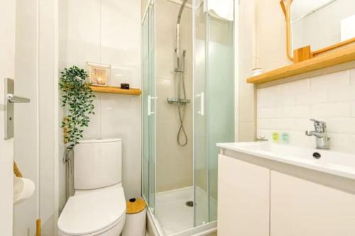 uma casa de banho com um WC, um chuveiro e um lavatório. em Le Janet3 YourHostHelper em Grenoble